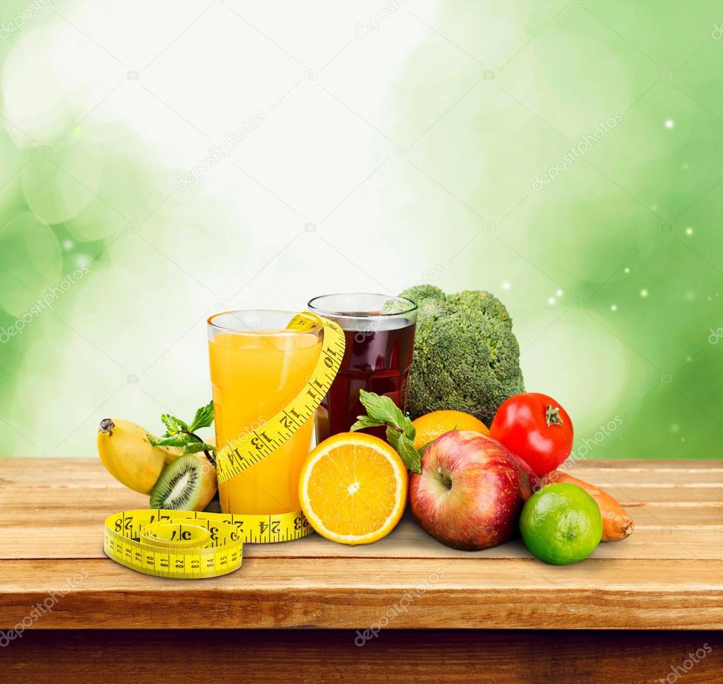Fresh fruits and juices and measuring tape 