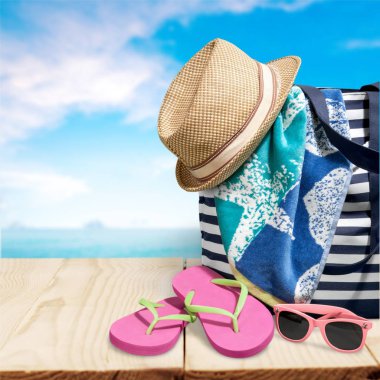 parmak arası terlik, şapka ve arka planda plaj çantası 