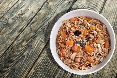 Ahşap masada kase içinde Tahıl granola