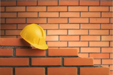 tuğla duvar arka plan üzerinde sarı kask 