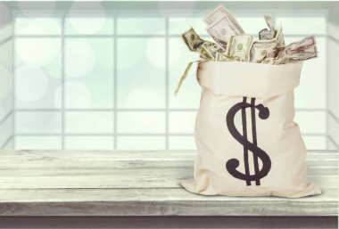 Ahşap arka plan üzerinde para dolu çanta 