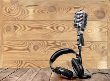 Retro tarzı mikrofon ve kulaklık üzerinde ahşap masa