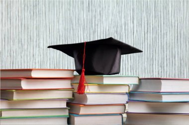 Mezuniyet şapka ve kitap yığını 