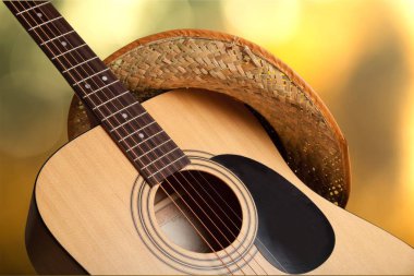 Açık renkli şapka ile akustik gitar