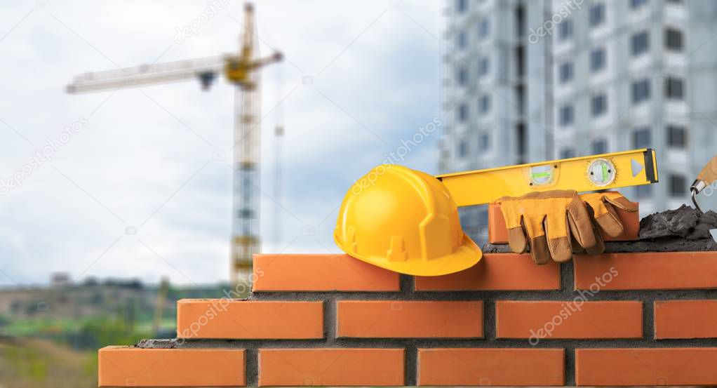 yellow helmet with equipment on construction background