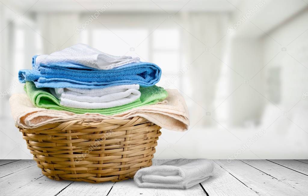 Pile of fluffy towels on light background