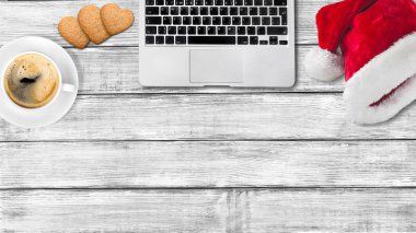 santa şapka, modern dizüstü bilgisayar, kahve fincanı ve bisküvi 