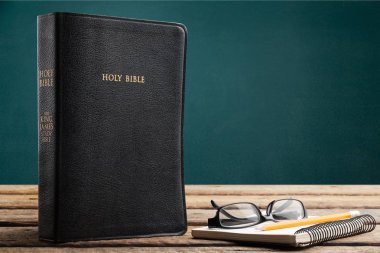 Kutsal İncil kitap, defter ve ahşap masa gözlük 