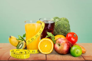 çeşitli taze meyve ve sebze, portakal suyu ve şerit metre yeşil çimen, sağlıklı gıda diyet kavramı için üzerinde 