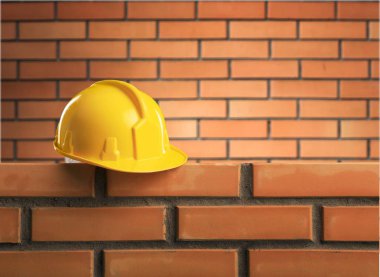 Sarı baret brickwall, inşaat kavramı üzerinde