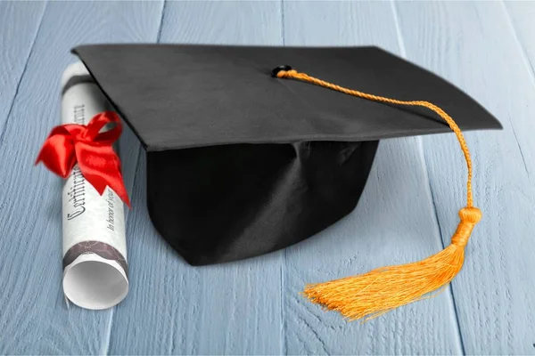 卒業の帽子 本と木製のテーブルに卒業証書 — ストック写真