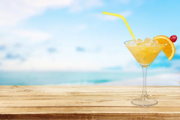 沙滩上配有酒精鸡尾酒的玻璃杯 — 图库照片