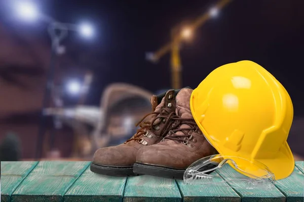 hard hat and work boots on wooden table