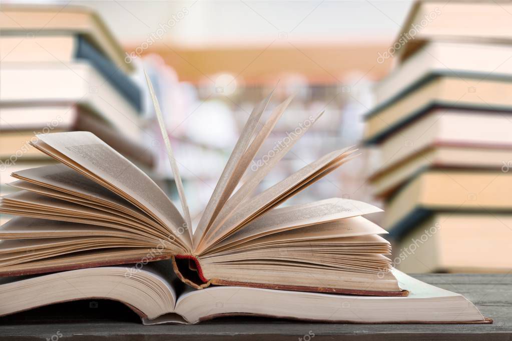 pile of books and stationery in library on blurred background 