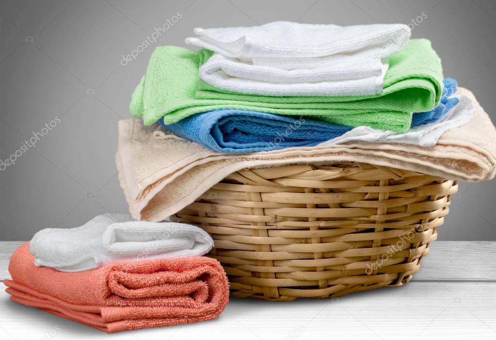 Pile of fluffy towels on light background