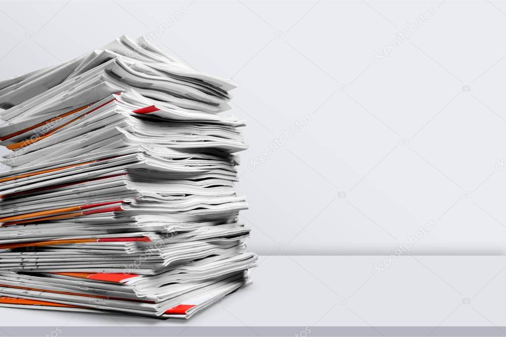 Stacked printed Magazines isolated on light background