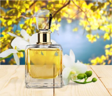 Parfüm şişesi ve ahşap masaya çiçek