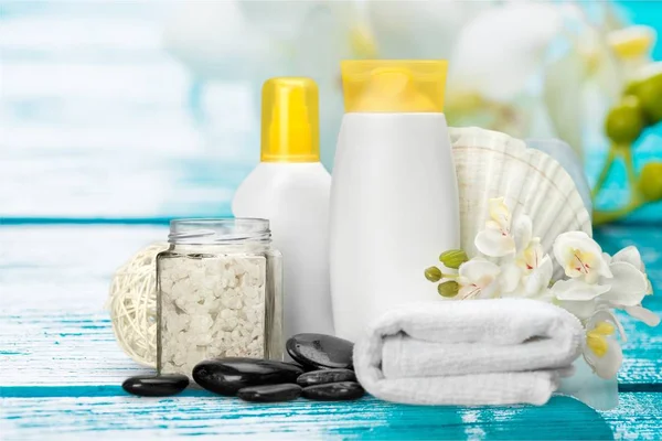 Spa Treatment Concept White Towel Bottles Cosmetics Flowers Hot Stones — Stock Photo, Image