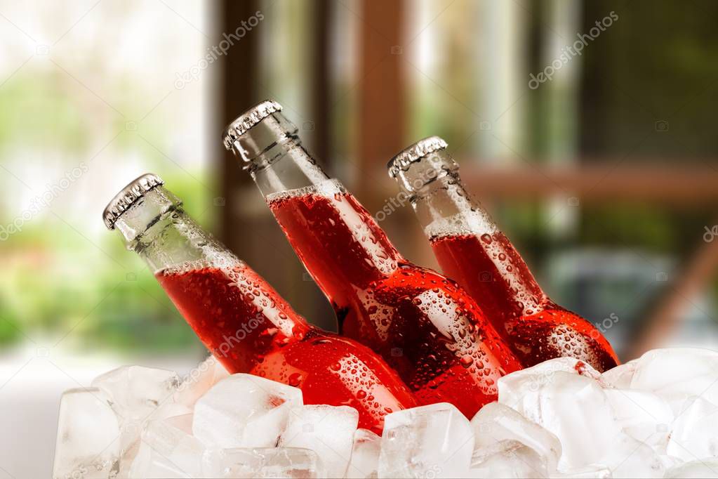 Beer bottles with ice on blurred background