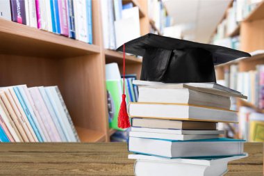Mezuniyet şapka ve kitap yığını