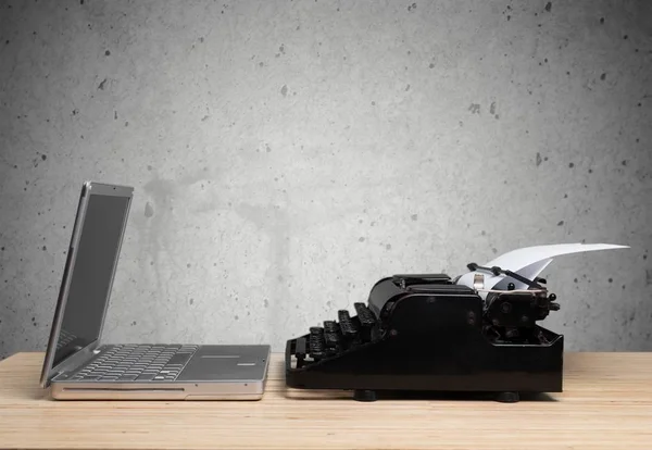 Old fashioned typewriter with a modern laptop