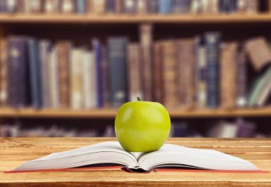 Masada yeşil elma ile açık kitap