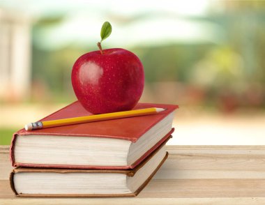 kitap yığını, kalem ve taze kırmızı elma, eğitim ve öğrenme arka plan