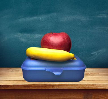 kırmızı elma ve muz öğle yemeği kutusu karşı yazı tahtası, okul öğle yemeği bulanık