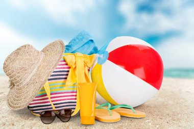 floplar flip ve losyon kumlu kıyısında plaj çantası içinde tan