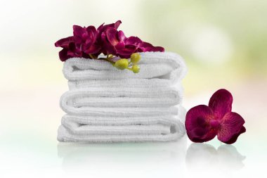 Beyaz kabarık havlu ve pembe çiçekler yığını