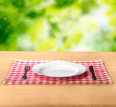 Ahşap masada çatal ve mutfak bıçağı ile plaka