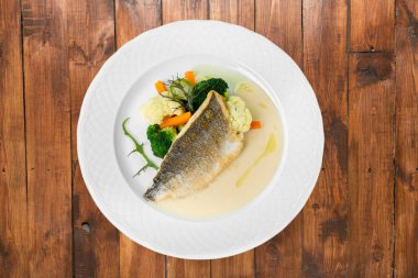 Beyaz tabakta sebzeli ızgara balık