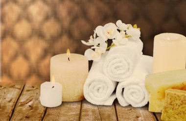 Kabarık parlak havlu yığını, mumlar yanan, beyaz çiçekler