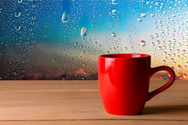 Taza Rojo Sobre Mesa Madera Contra Fondo Ventana Mojado —  Fotos de Stock