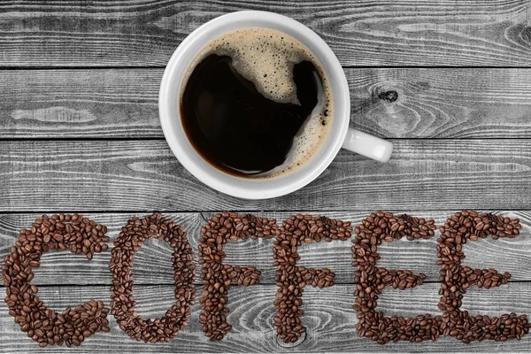 Tasse Kaffee Und Verstreute Kaffeebohnen Auf Holzgrund — Stockfoto