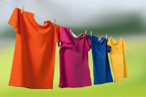 T-shirts coloridas penduradas na corda — Fotografia de Stock