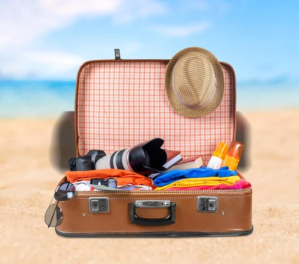 茶色の革ヴィンテージ スーツケース カメラ 砂浜で麦わら帽子 — ストック写真