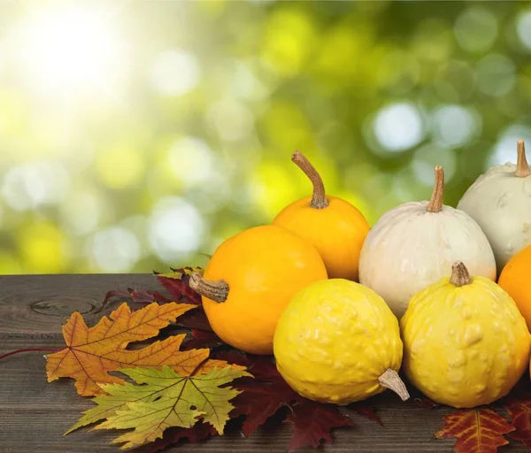 Kürbisse Und Herbstblätter Auf Holztisch — Stockfoto