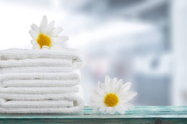 Kabarık havlu ve papatya çiçeği yığını