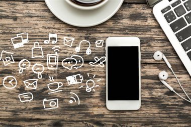 ahşap arka planda dizüstü bilgisayar, akıllı telefon ve kahve