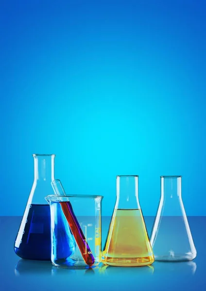Glass laboratory flasks on light background