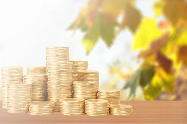 Golden coins on wooden table, investment and money