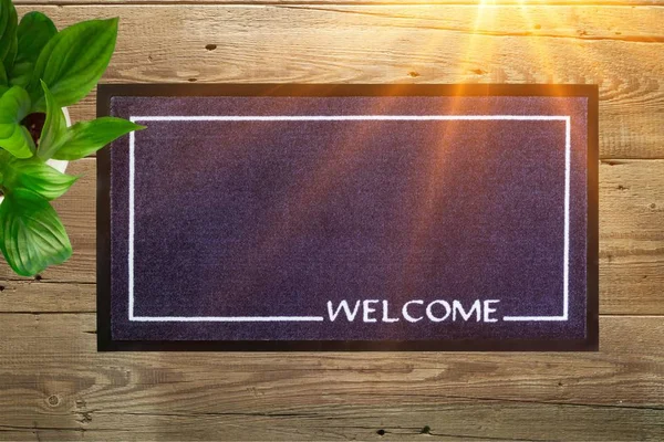 New welcome doormat on wooden floor