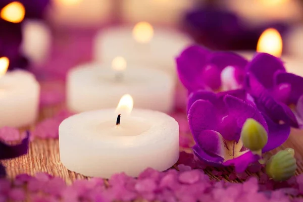 Wellnessdekoration Lila Blumen Und Brennende Kerzen — Stockfoto