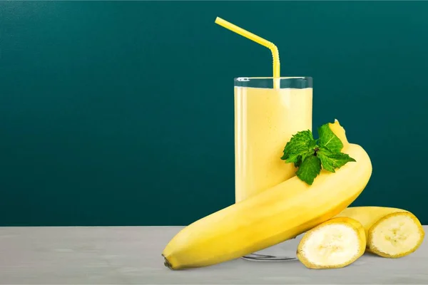 tasty banana juice in glass and raw bananas