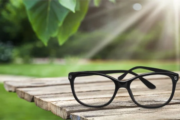 Single eyeglasses on table against blurred background