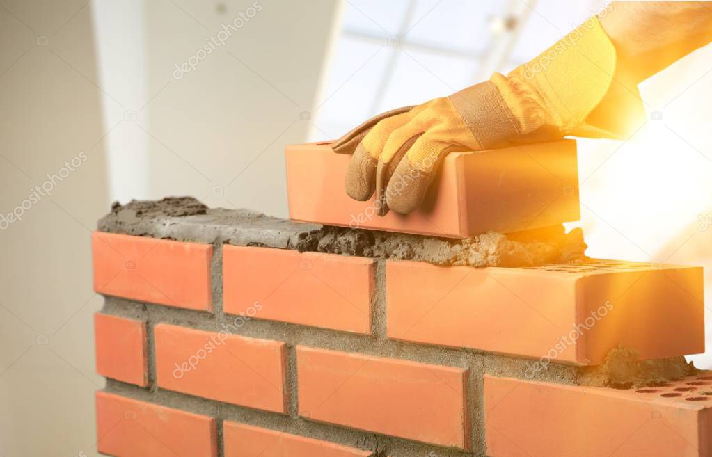 Masonry work, bricklayer constructing brickwall