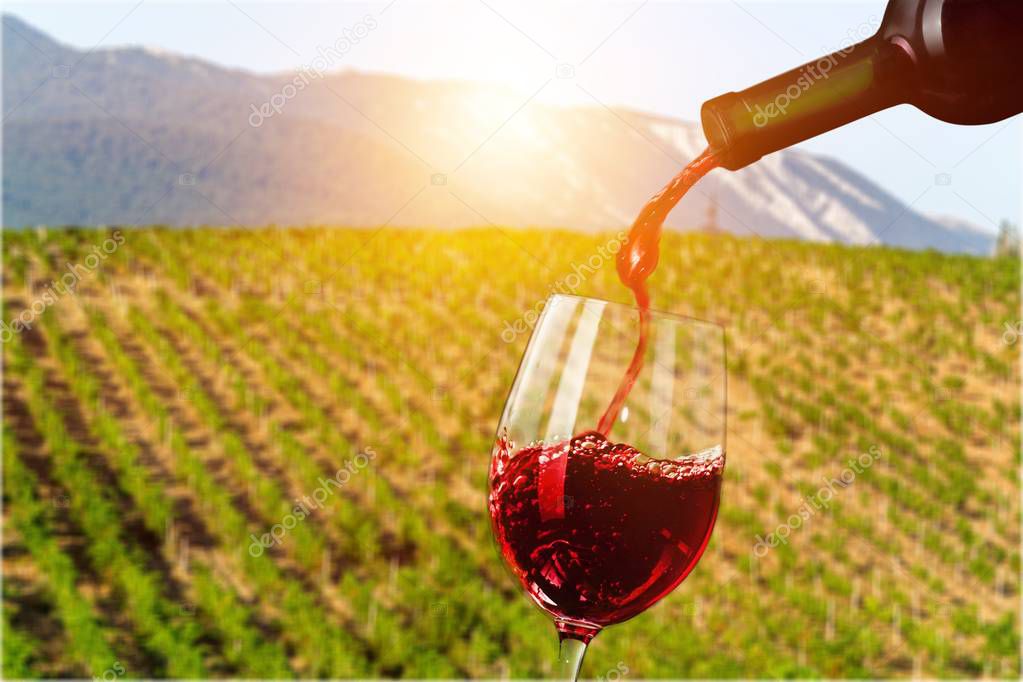 Red wine being poured in wineglass, closeup