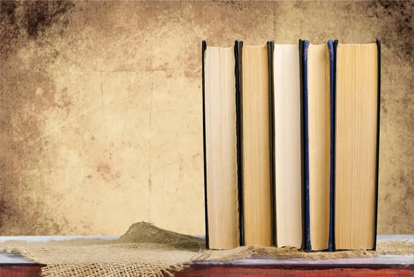 Stack of vintage books on  background