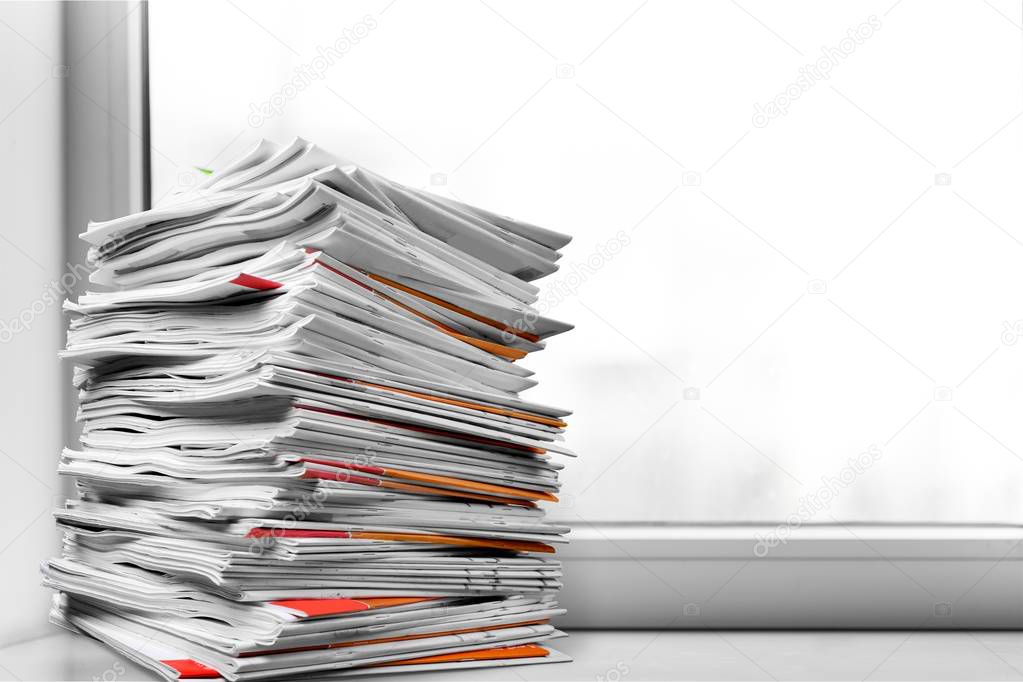 Stacked printed Magazines isolated on light background 
